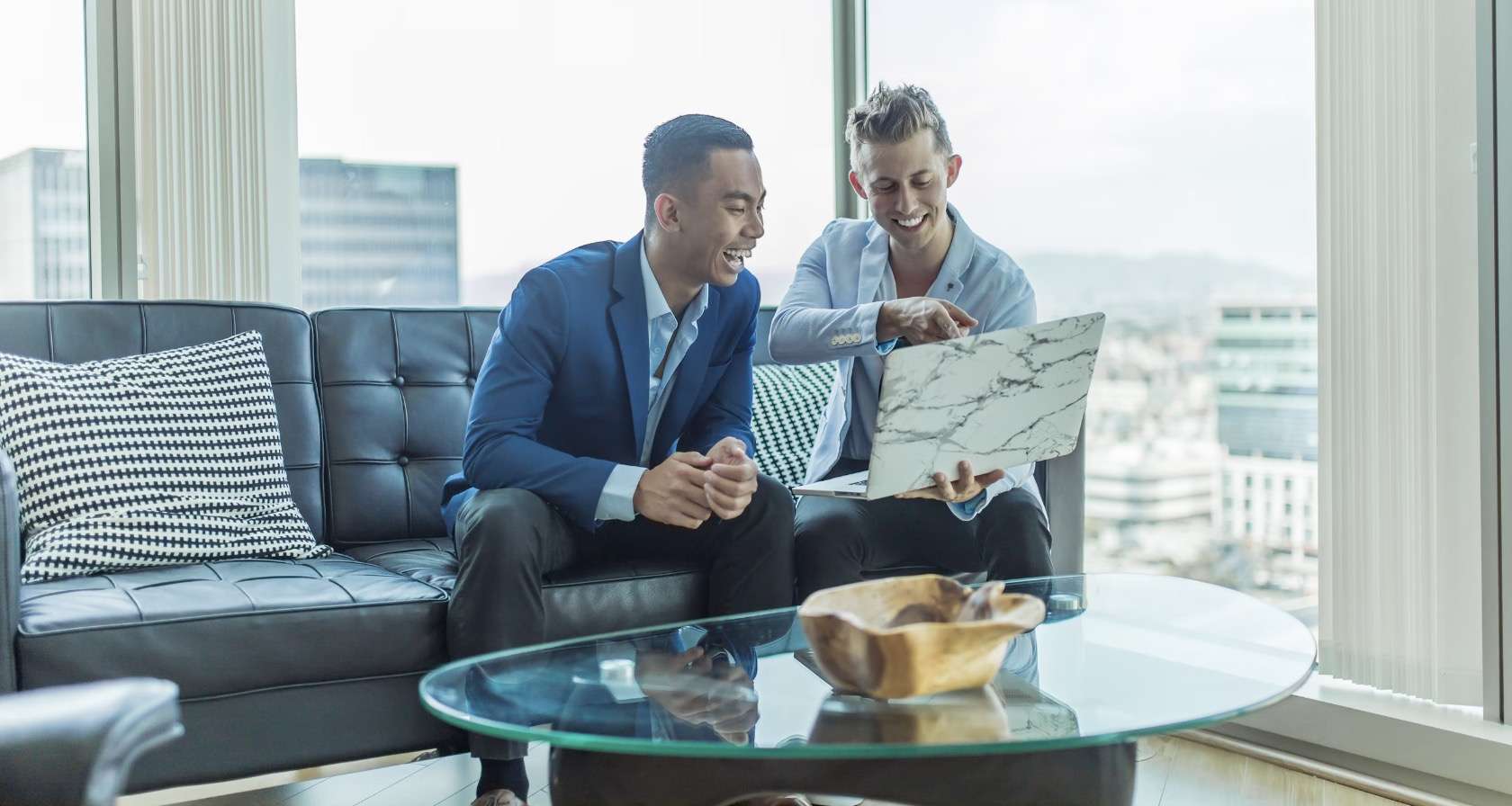 twee ondernemers aan het werk en lachen met laptop